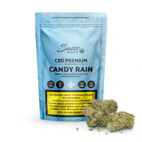 Fleurs de cbd indoor candy rain comprend un sachet bleu contenant 27 % de cbd, de petites têtes de cannabis vertes et des étiquettes d'avertissement multilingues garantissant clarté et sécurité pour votre expérience premium.